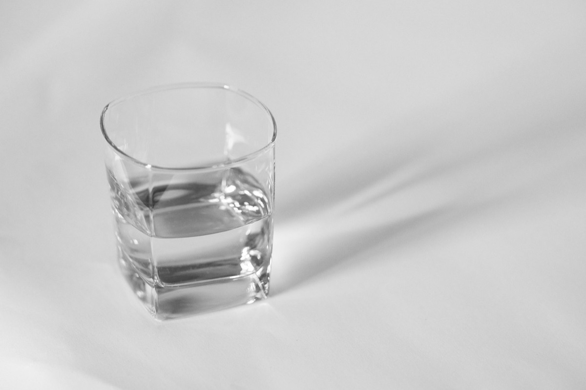 persona che guarda un pasto con un bicchiere d'acqua