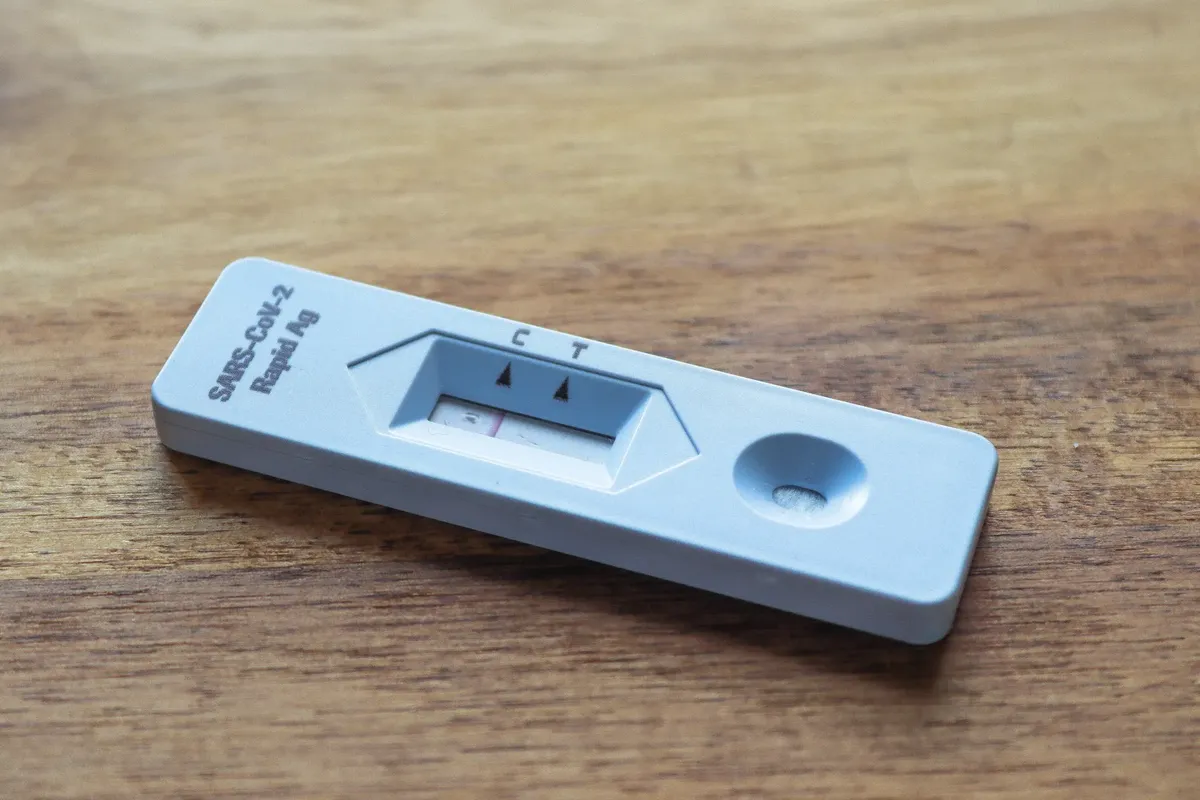 Close-up of a COVID-19 rapid antigen test on a wooden surface for health screening.