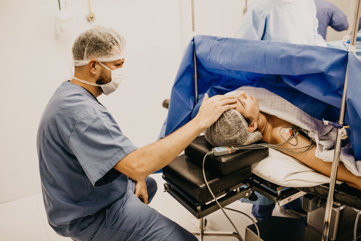 camera looking at a patient and family in hospital gown and surgical mask