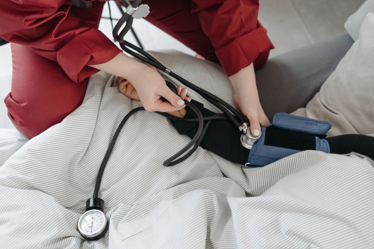 A stethoscope and blood pressure cuff on a clinical table.