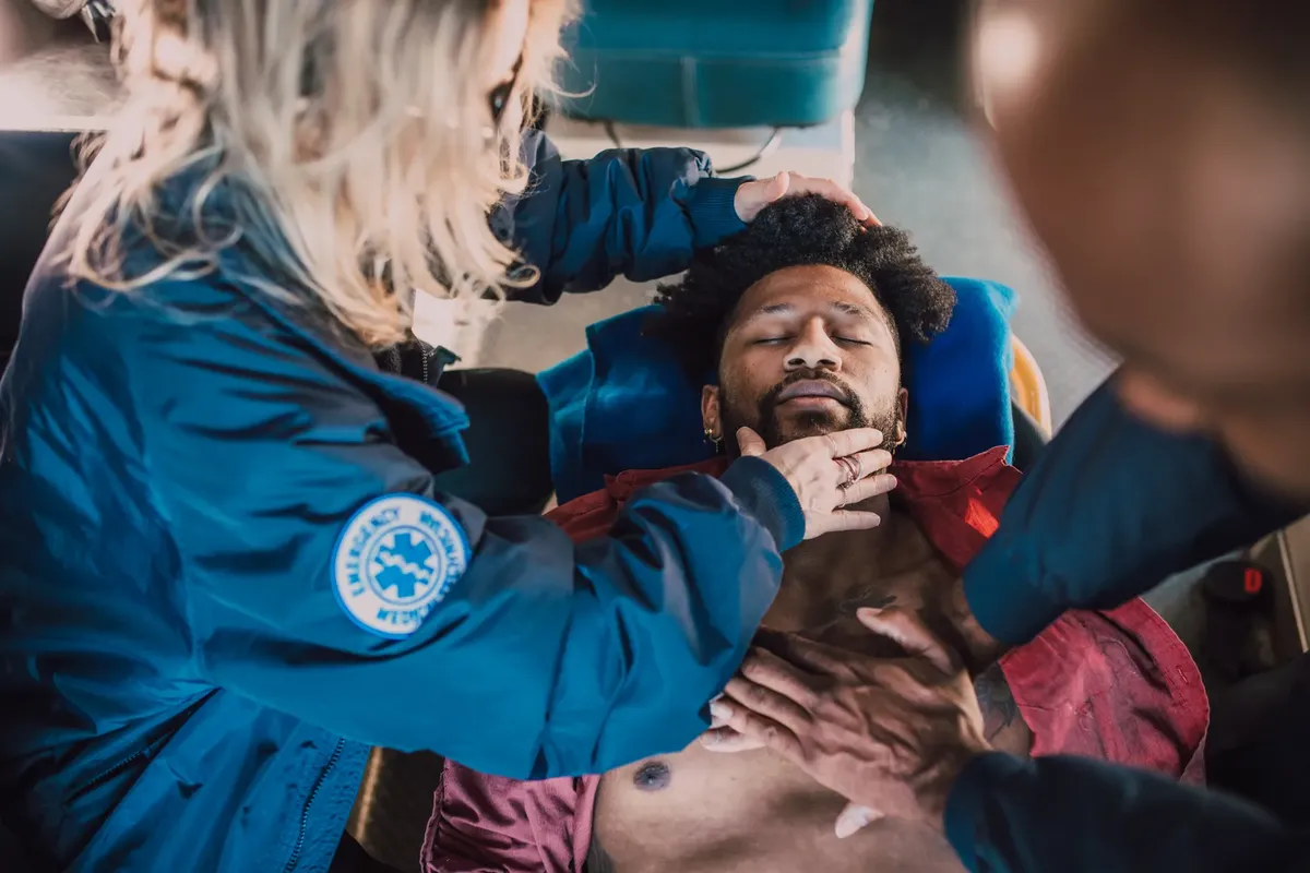 Paramedics administer life-saving CPR to unconscious patient during emergency response.