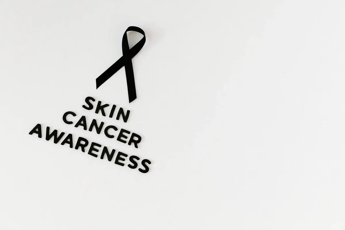 Black ribbon and text promoting skin cancer awareness on a white background.